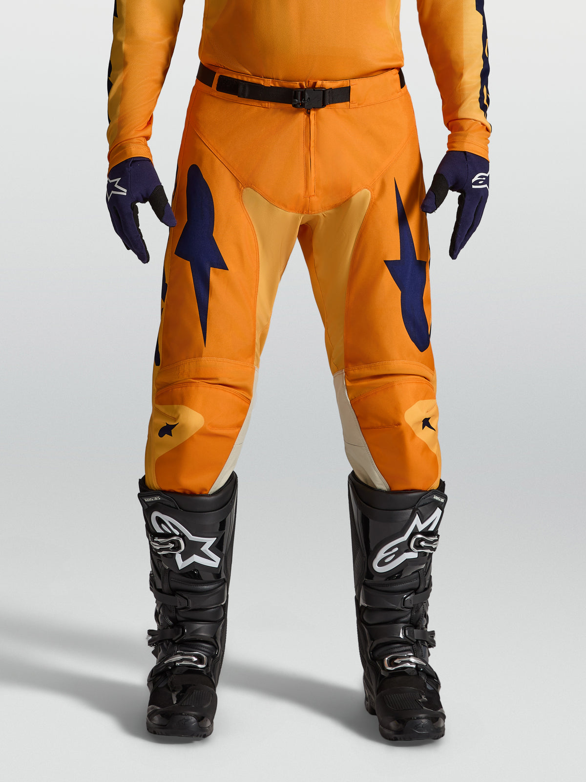 Alpinestars Racer Amber, męskie spodnie motocrossowe, pomarańczowe i ciemnoniebieskie, wytrzymały poliester 600D, sportowy krój do jazdy off-road.