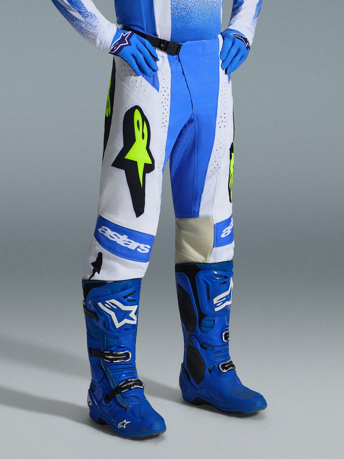 Alpinestars 2026 Techstar Knif Pants, Motocross Pants, Ucla Blue, Black, and Yellow Fluo, worn with matching blue motocross boots and gloves, featuring white panels, large yellow fluo star logos, and athletic off-road design