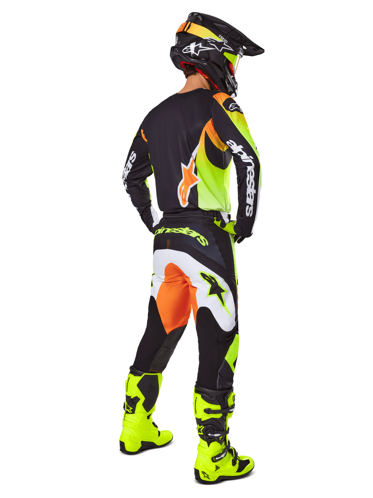 Jeździec motocrossowy widziany z tyłu w zestawie Alpinestars 2025 Fluid Wurx, czarna koszulka z żółtymi i pomarańczowymi akcentami, pasujące czarne spodnie z białymi i pomarańczowymi panelami, jaskrawożółte buty i czarny kask, kompletny strój wyścigowy off-road