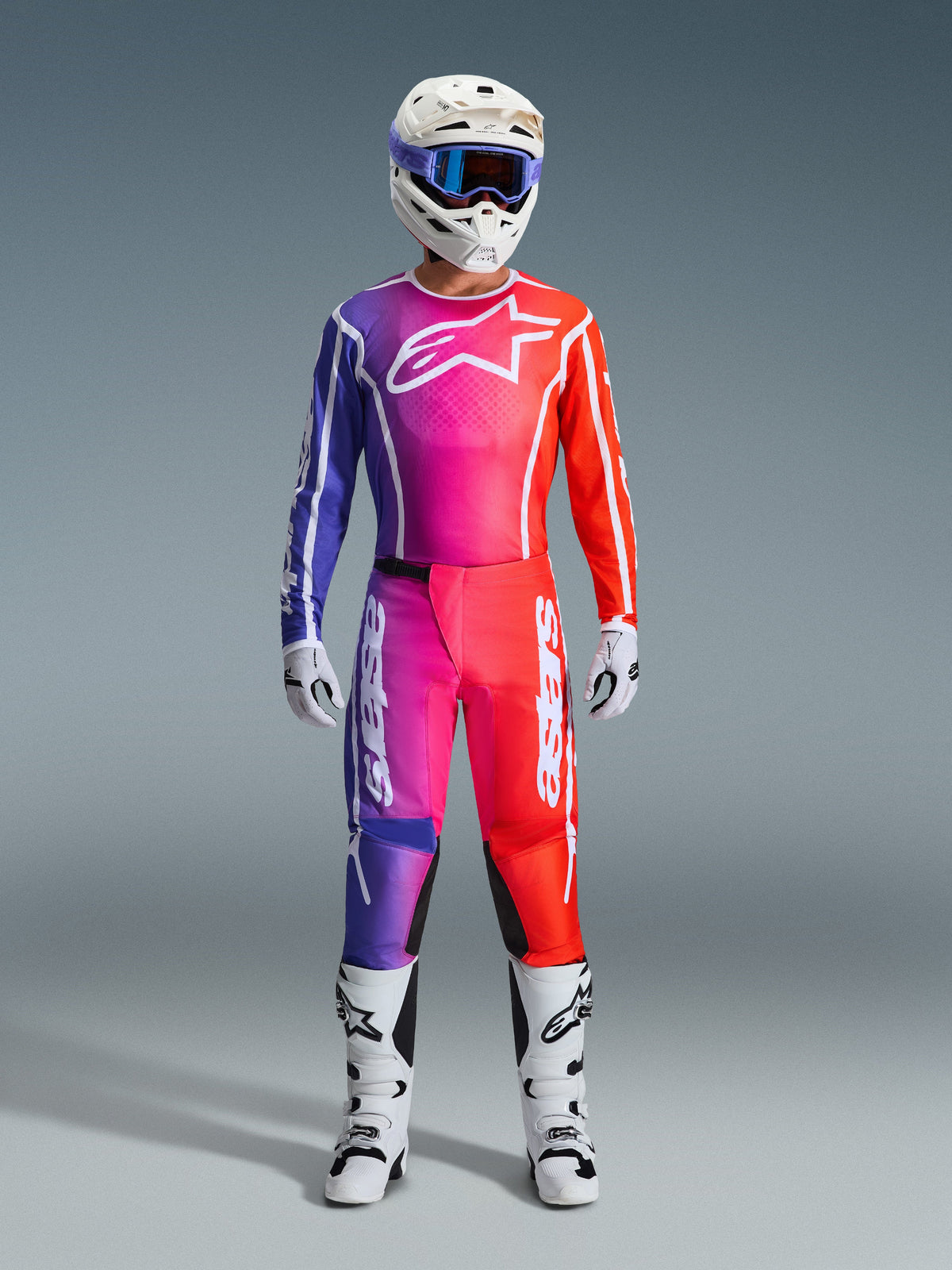 Alpinestars 2026 Fluid Apex Gear Set, strój motocrossowy, gradient fioletowego, różowego i czerwonego z białymi akcentami, kompletny zestaw wyścigowy z białym kaskiem, niebieskimi goglami i białymi butami, kolorowa odzież off-road o wysokiej wydajności