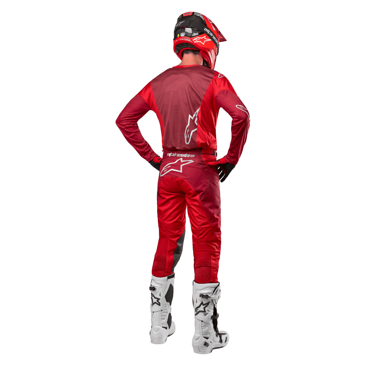 Alpinestars 2024 Racer Hoen Pants and matching jersey in Mars Red Burgundy, rear view of a motocross rider in full gear including a red helmet and white boots, showcasing the athletic fit and branding for off-road racing.