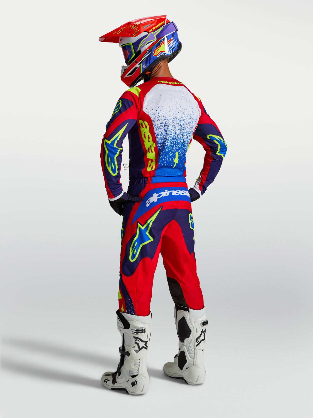 Alpinestars spodnie Fluid Drag i zestaw 2027 Fluid Drag Gear Set, niebiesko-czerwony strój motocrossowy, białe buty, tył.