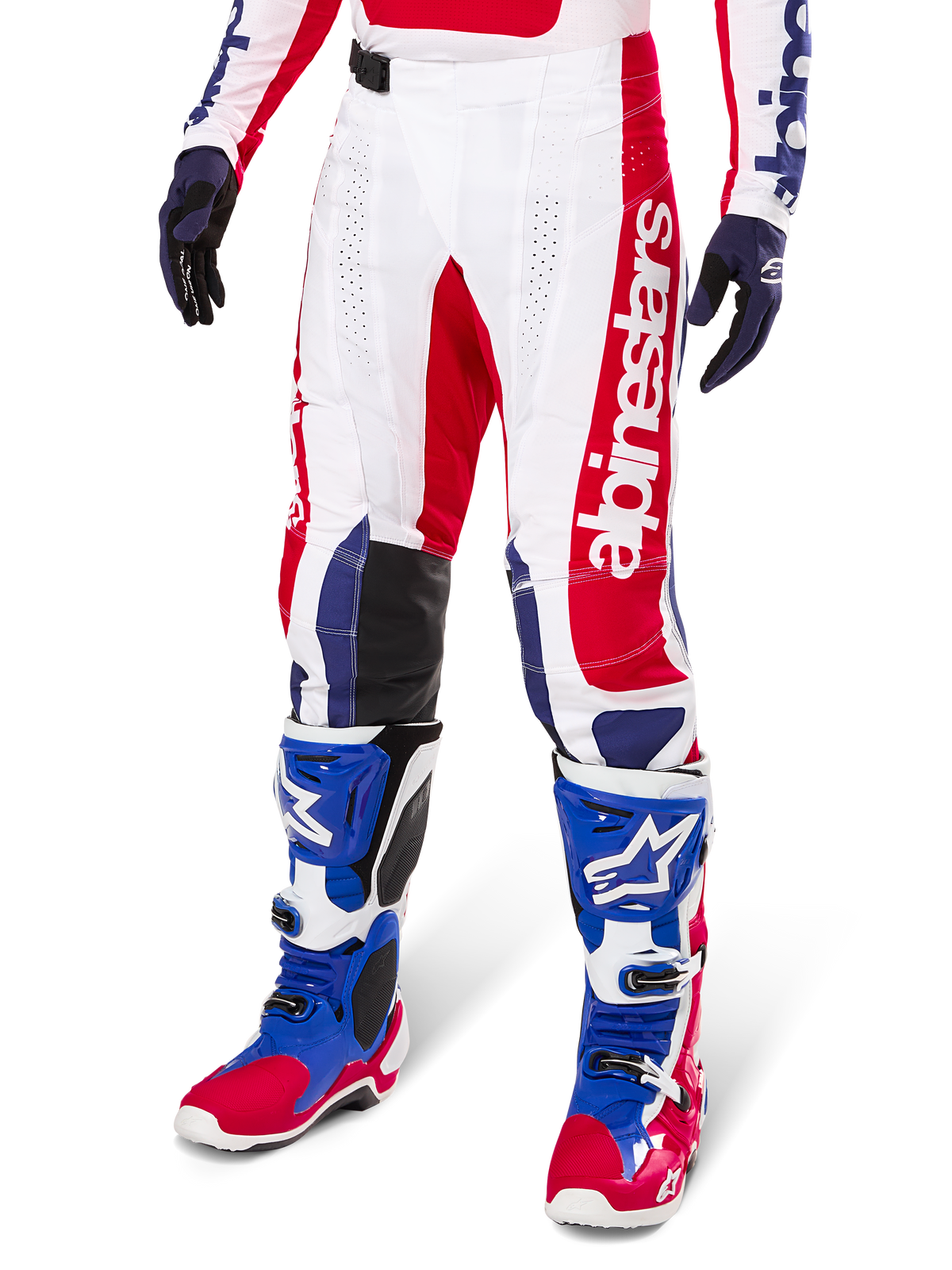Alpinestars Limited Edition Techstar Fortitude Motocross Pants, spodnie motocrossowe, czerwono-biało-niebieska kolorystyka, noszone z dopasowanymi butami i rękawicami, pionowy branding Alpinestars, sportowy krój do wyścigów off-road