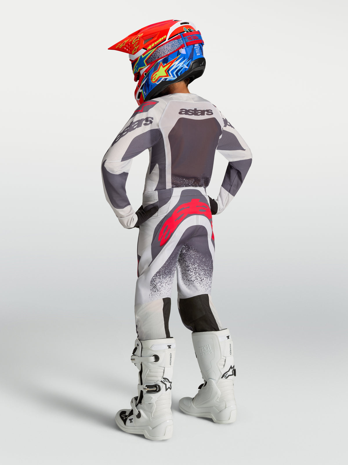 Alpinestars spodnie Supertech Swan młodzieżowe, szare i czerwone spodnie motocrossowe, widok z tyłu na sportowy krój.