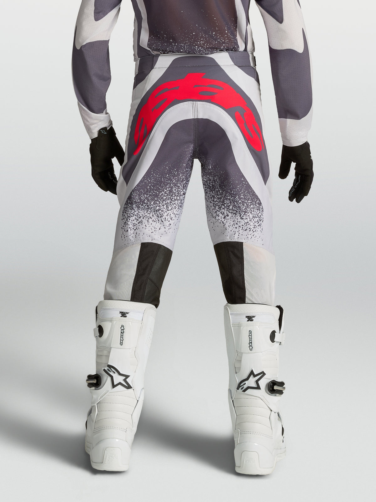 Alpinestars Supertech Swan, młodzieżowe spodnie MX, szare i czerwone fluo, tył, sportowy krój i wzmocnione siedzisko.