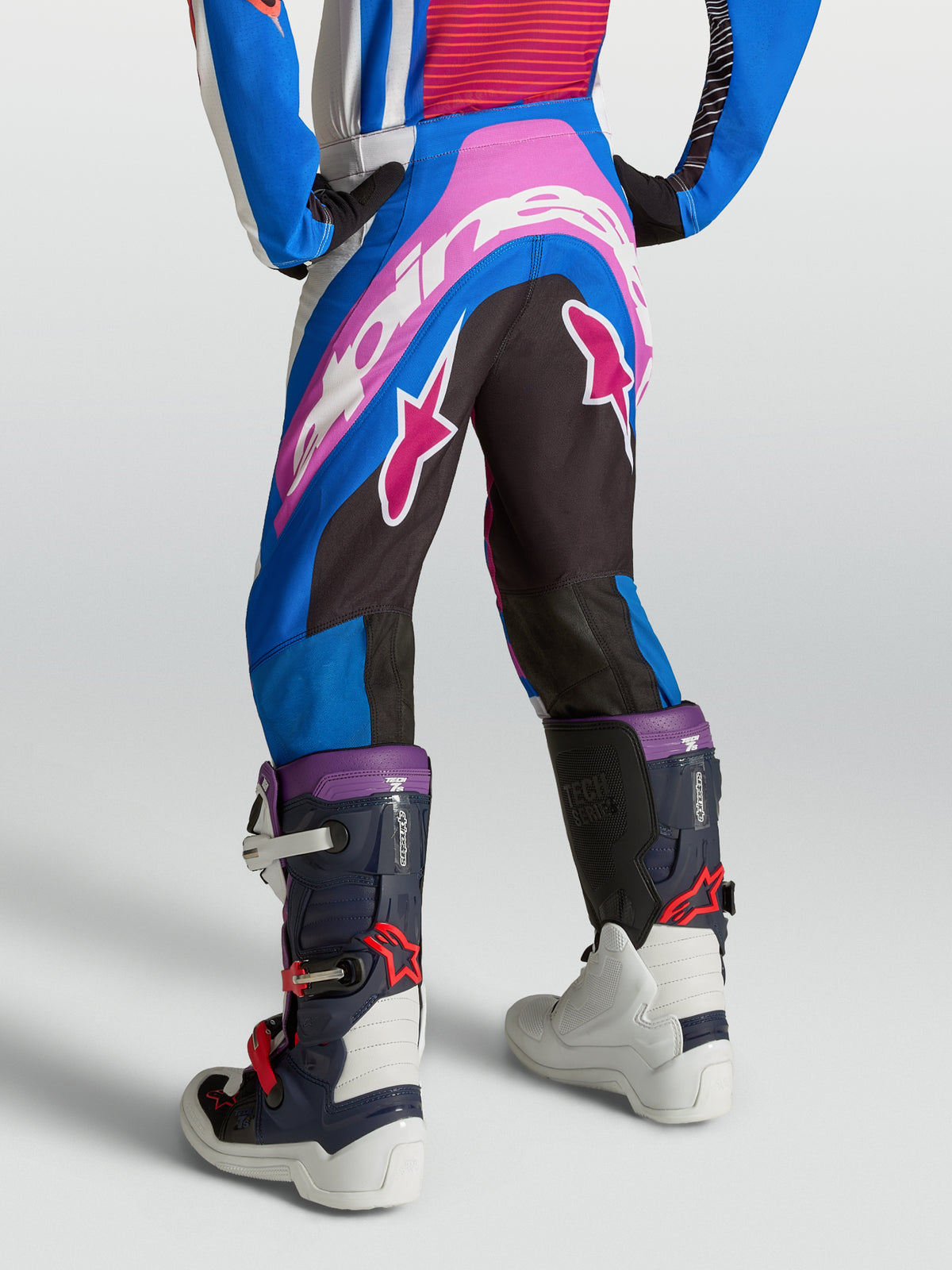 Alpinestars Spodnie Supertech Maven Młodzieżowe, niebieskie, różowe i białe, motocrossowe, widok z tyłu z logo na siedzeniu.