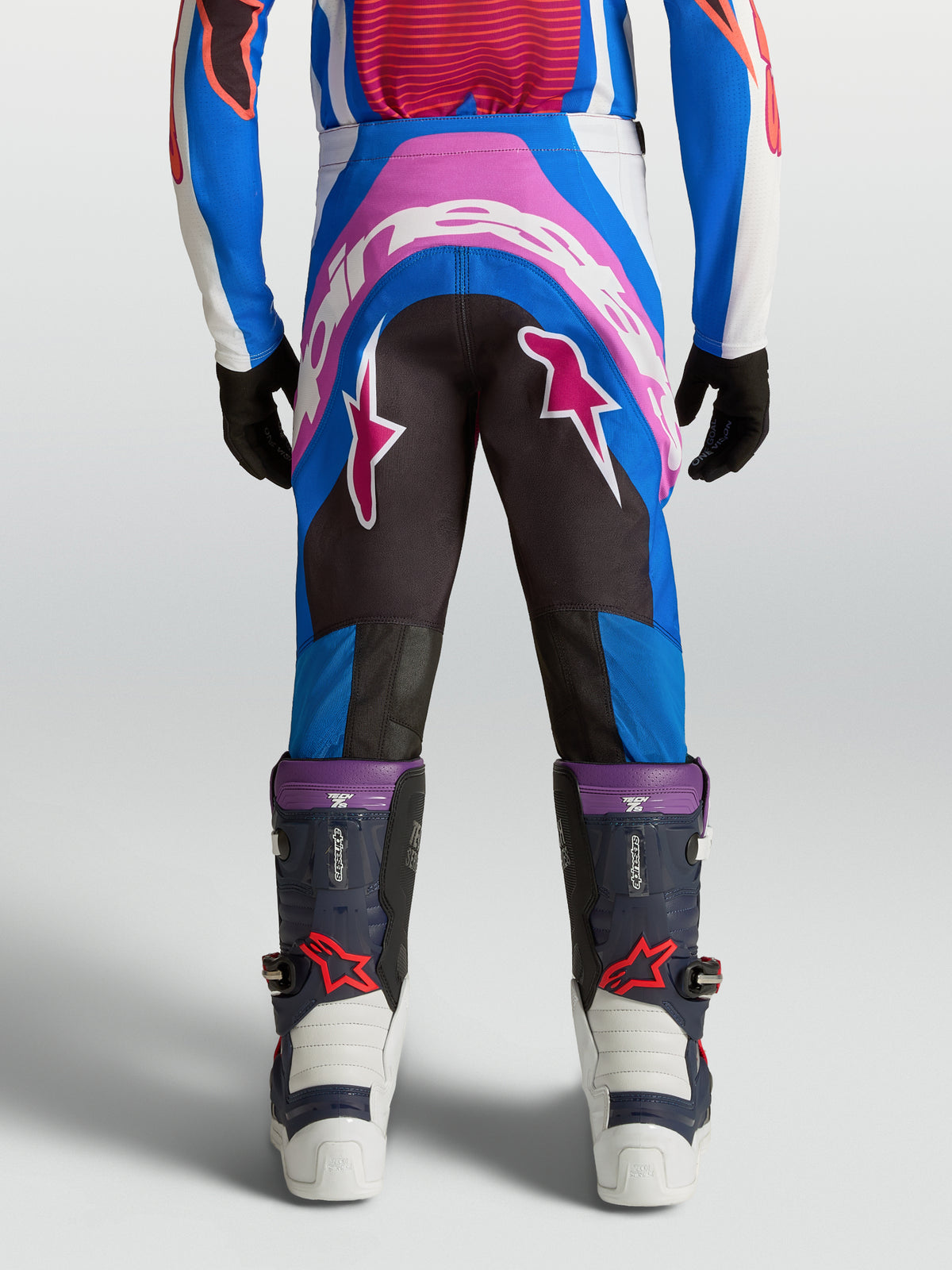 Alpinestars Supertech Maven, młodzieżowe spodnie motocrossowe, niebieskie i różowe, wzmocnione siedzisko, sportowy krój.