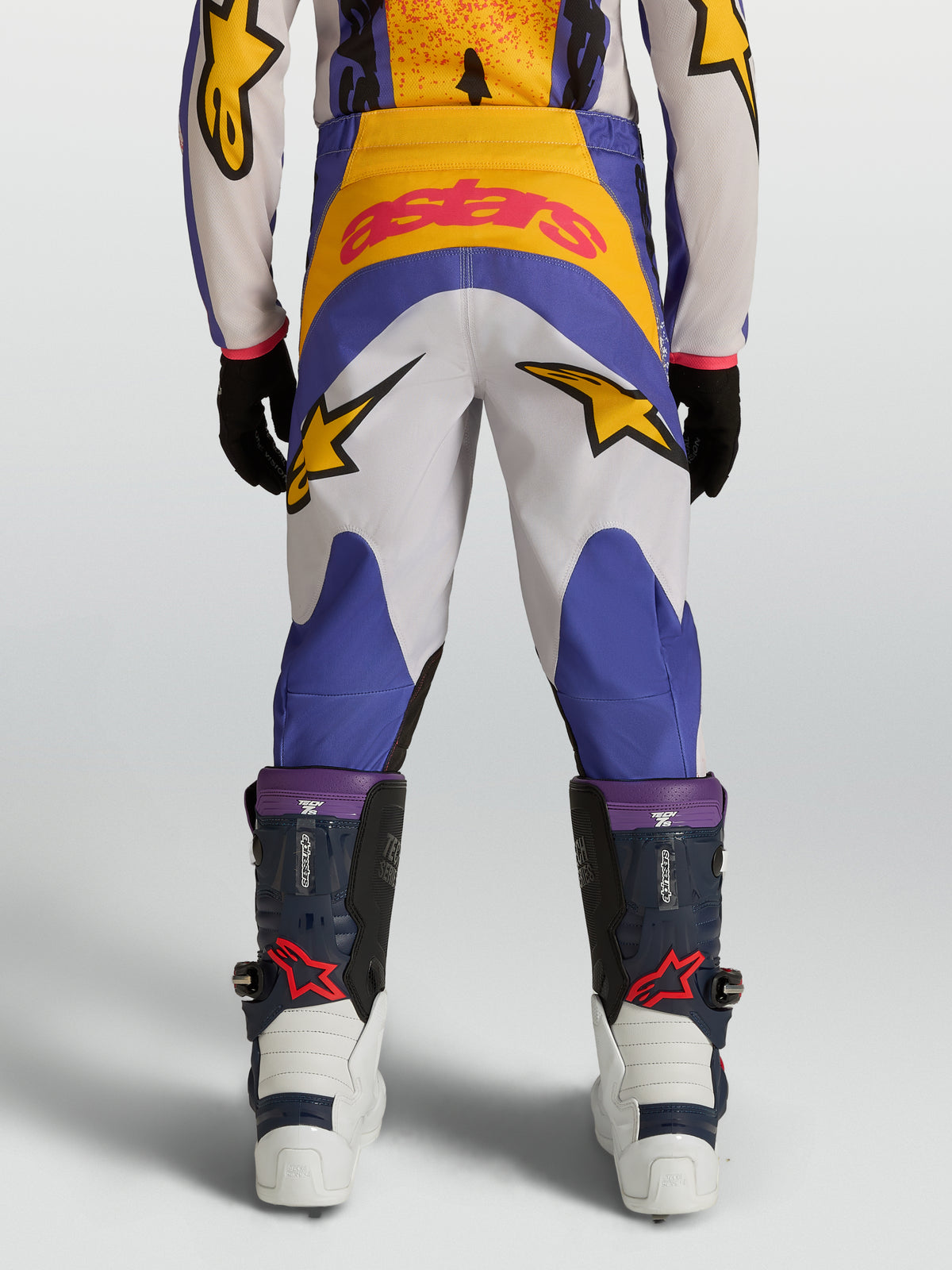 Alpinestars Youth Fluid Drag, młodzieżowe spodnie motocrossowe, niebieskie i złote, wytrzymały poliester 600D, grafika z logo gwiazdy, widok z tyłu