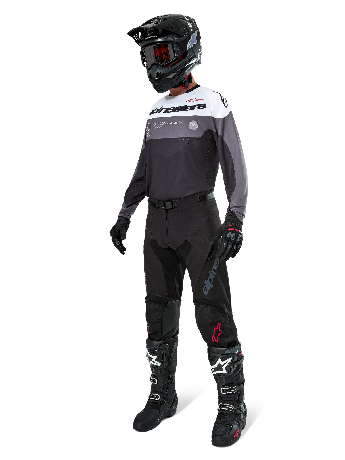 Koszulka Alpinestars Pro-Dura w kolorze Black Magnet White, noszona przez motocyklistę motocrossowego w pełnym stroju, w tym czarne spodnie, czarny kask z goglami oraz czarno-białe buty. Koszulka posiada techniczny design z białymi, szarymi i czarnymi panelami, stworzona z myślą o wydajności w enduro i off-road.