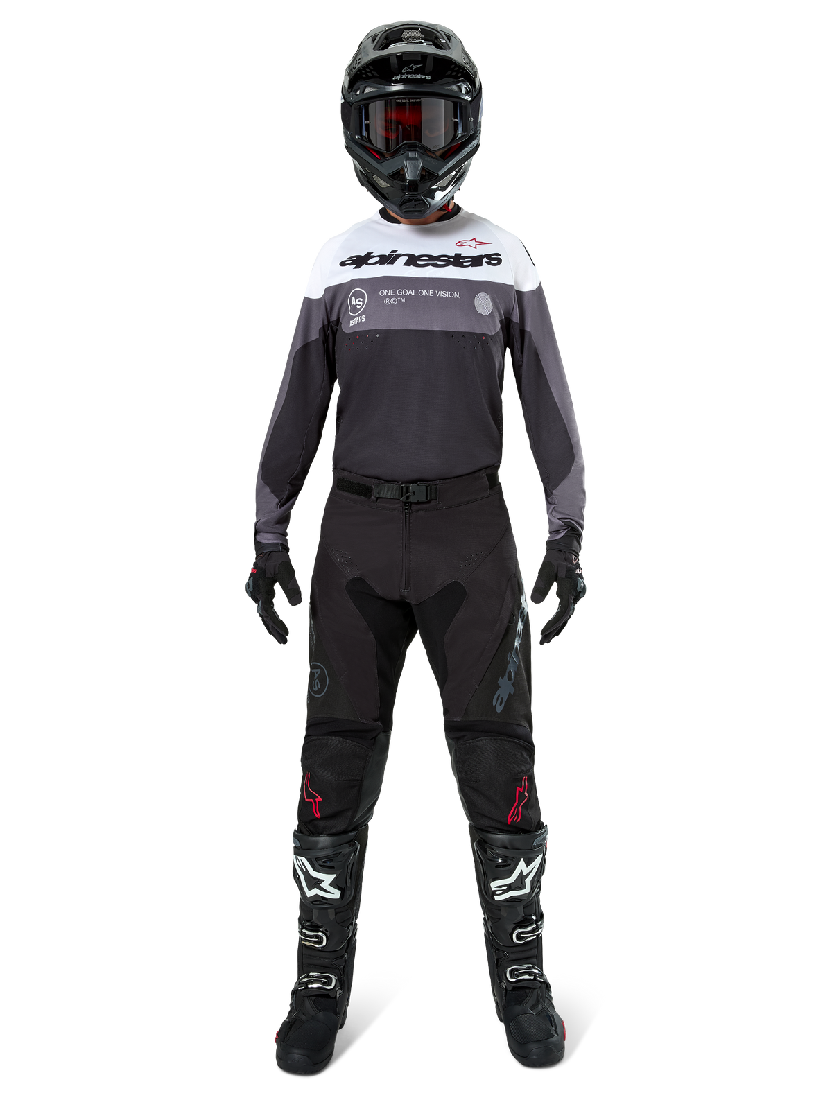 Zawodnik motocrossowy w pełnym stroju wyścigowym, koszulka Pro-Dura w kolorze Black Magnet White z białym górnym panelem i szarymi akcentami, czarne spodnie, czarny kask z ciemnymi goglami, biało-czarne buty i czarne rękawice, dopasowany zestaw do wyścigów enduro i off-road