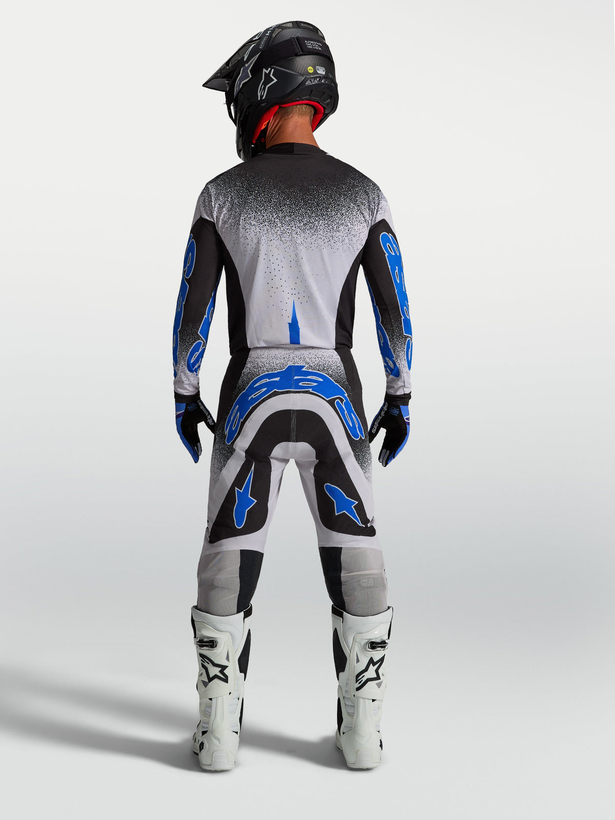 Koszulka i zestaw Alpinestars Supertech Hiten AFD, męski strój motocrossowy, czarny, biały i niebieski, widok od tyłu.