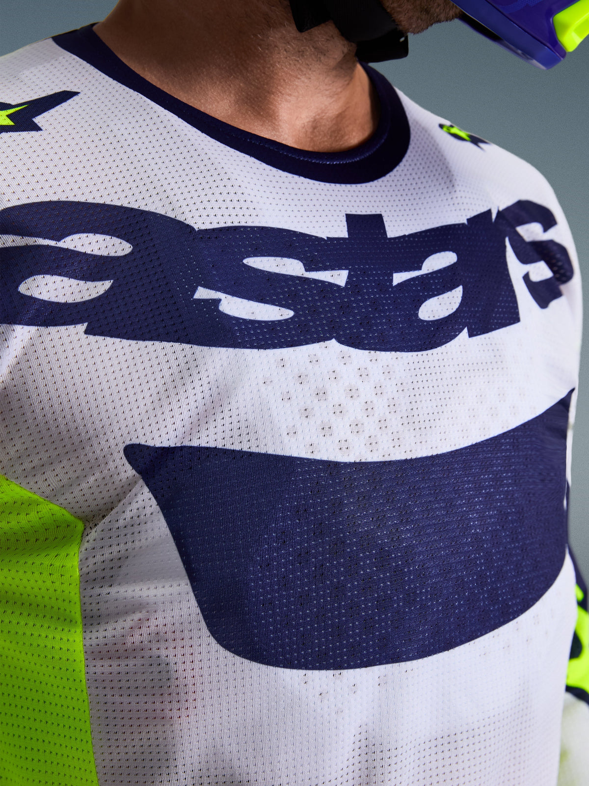 Alpinestars 2026 Racer Air Riway Jersey, koszulka motocrossowa, jasnoszara i granatowa z neonowym żółtym, zbliżenie na klatkę piersiową z logo „astars” i perforowaną siatką, sportowy krój do jazdy terenowej
