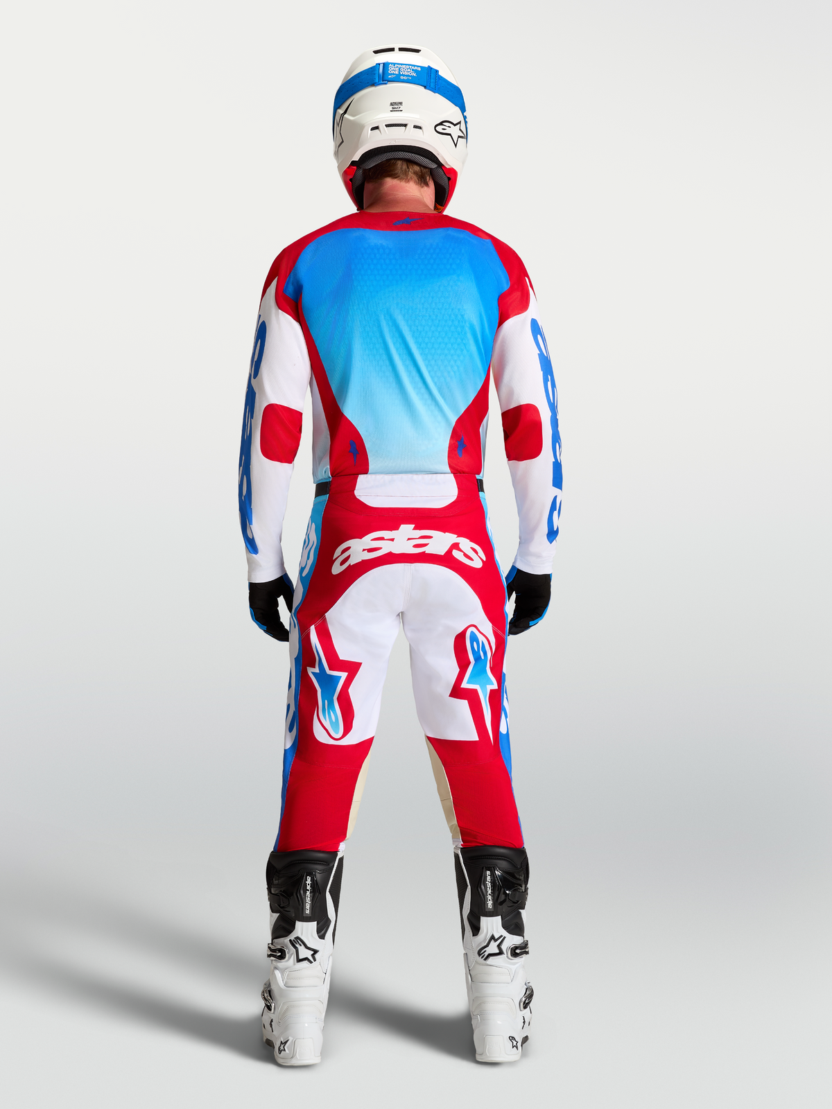 Alpinestars spodnie Racer Hunt i Racer Hunt Gear Set, czerwono-biało-niebieska odzież motocrossowa, widok z tyłu na modelu.