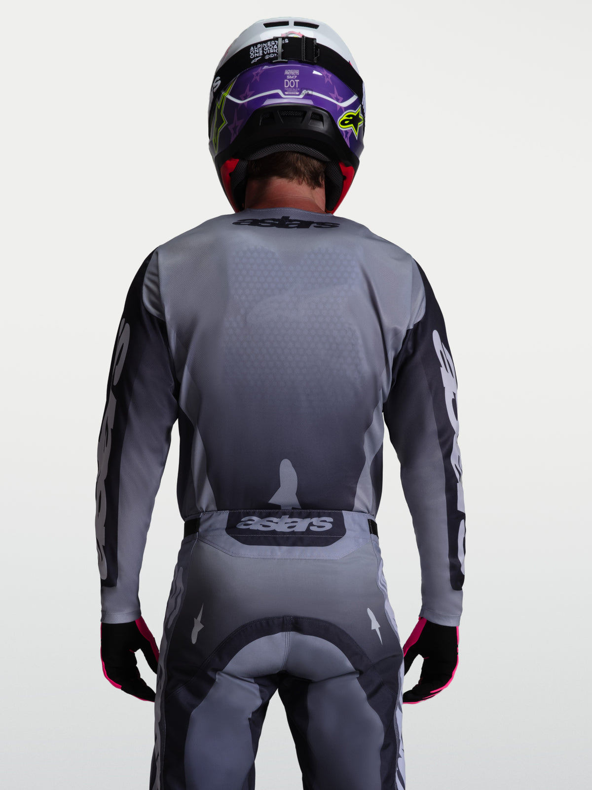 Koszulka Alpinestars Racer Amber, szara i jasnoliliowa wyczynowa koszulka motocrossowa do jazdy terenowej, widok z tyłu na modela.