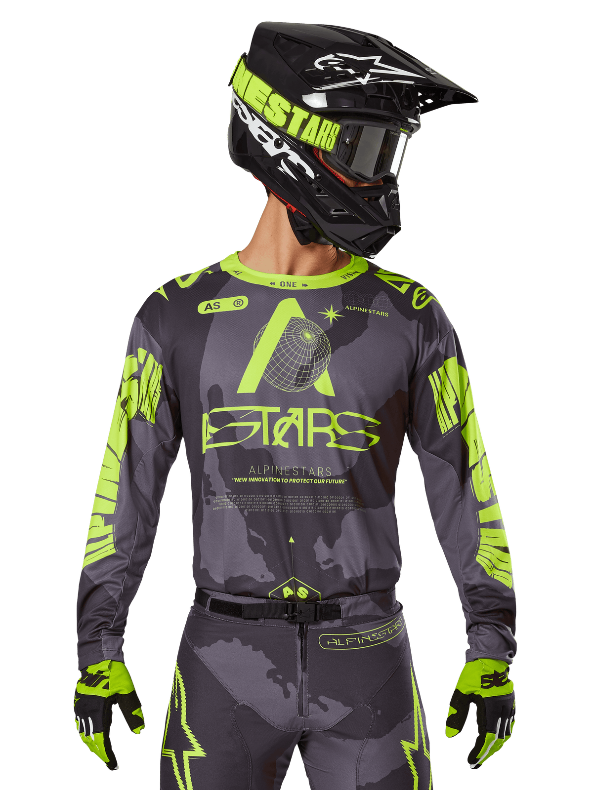 Alpinestars 2025 Racer Hollow Jersey, koszulka motocrossowa, ciemne moro i neonowy żółty, noszona z dopasowanymi spodniami, czarno-żółtym kaskiem z goglami i czarnymi rękawicami, logo Alpinestars i wzór kamuflażu