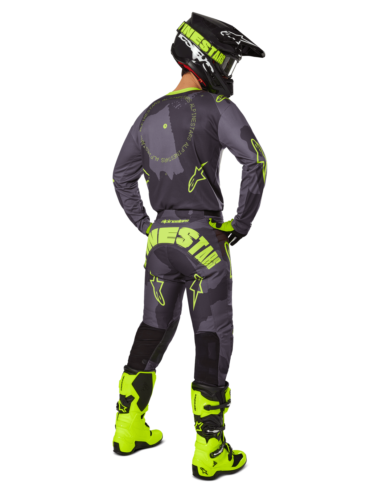 Rear view of a motocross rider wearing the 2025 Racer Hollow Gear Set in Dark Camo Yellow Fluo, featuring a gray camo jersey with yellow fluo accents, matching motocross pants with bold branding on the seat, bright yellow fluo boots, and a black helmet with yellow goggles.