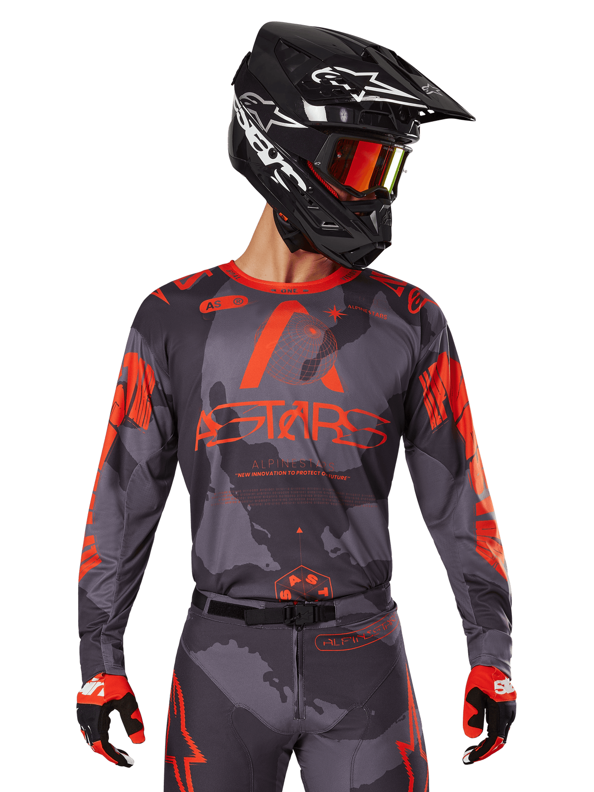 Alpinestars 2025 Racer Hollow Jersey, Motocross Jersey, Gray Camo and Orange Fluo, worn with matching gear set including pants and gloves, featuring a black helmet with white graphics and goggles, bold ASTARS branding, protective off-road racing sportswear