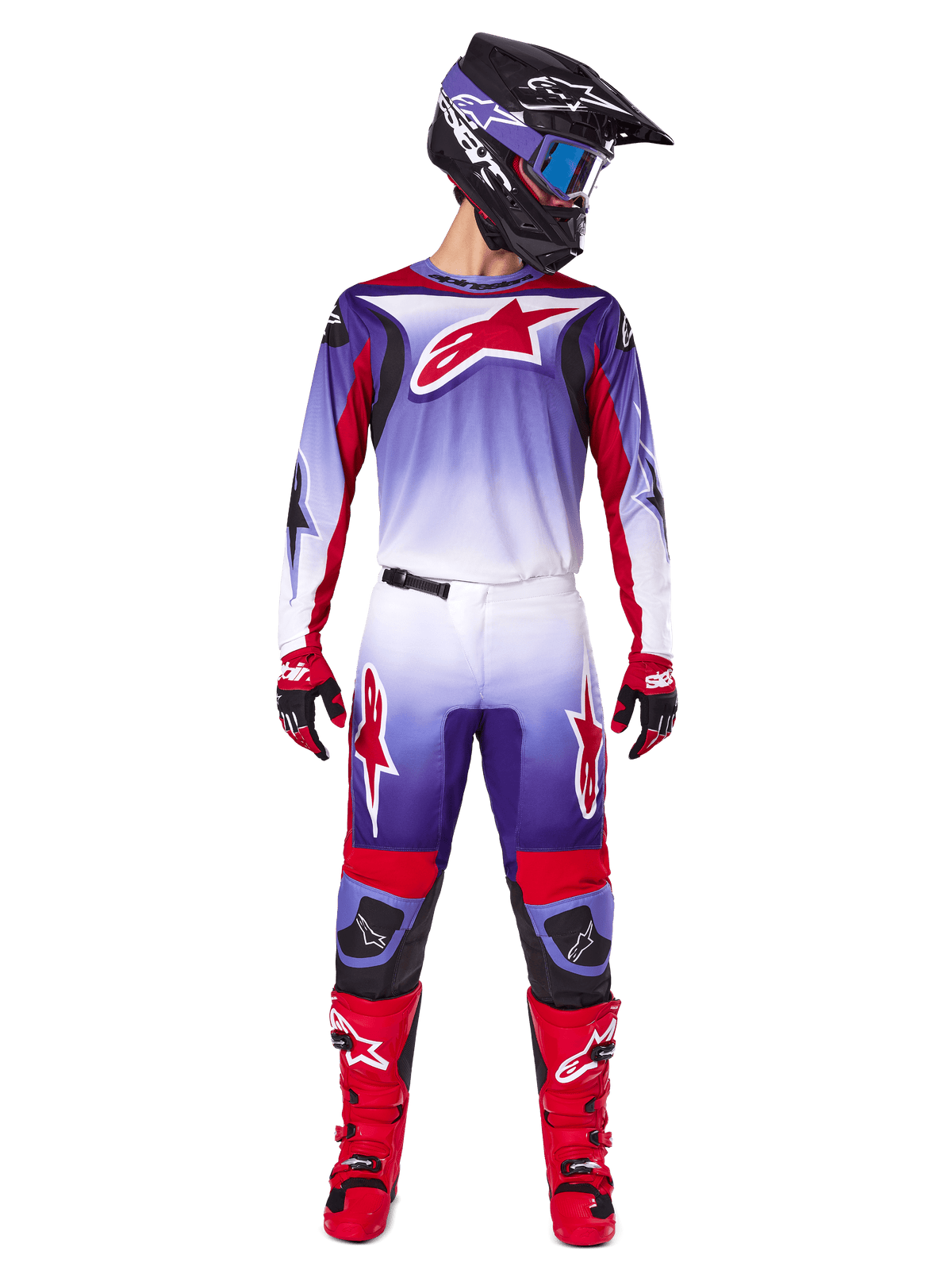Zawodnik motocrossowy w kompletnym stroju wyścigowym Alpinestars, koszulka Fluid Wurx 2025 w kolorze fioletowo-jasnoczerwonym z białymi akcentami i dużym czerwonym logo z gwiazdą, pasujące spodnie, czerwone buty oraz czarny kask z goglami, spójny zestaw do wyścigów off-road