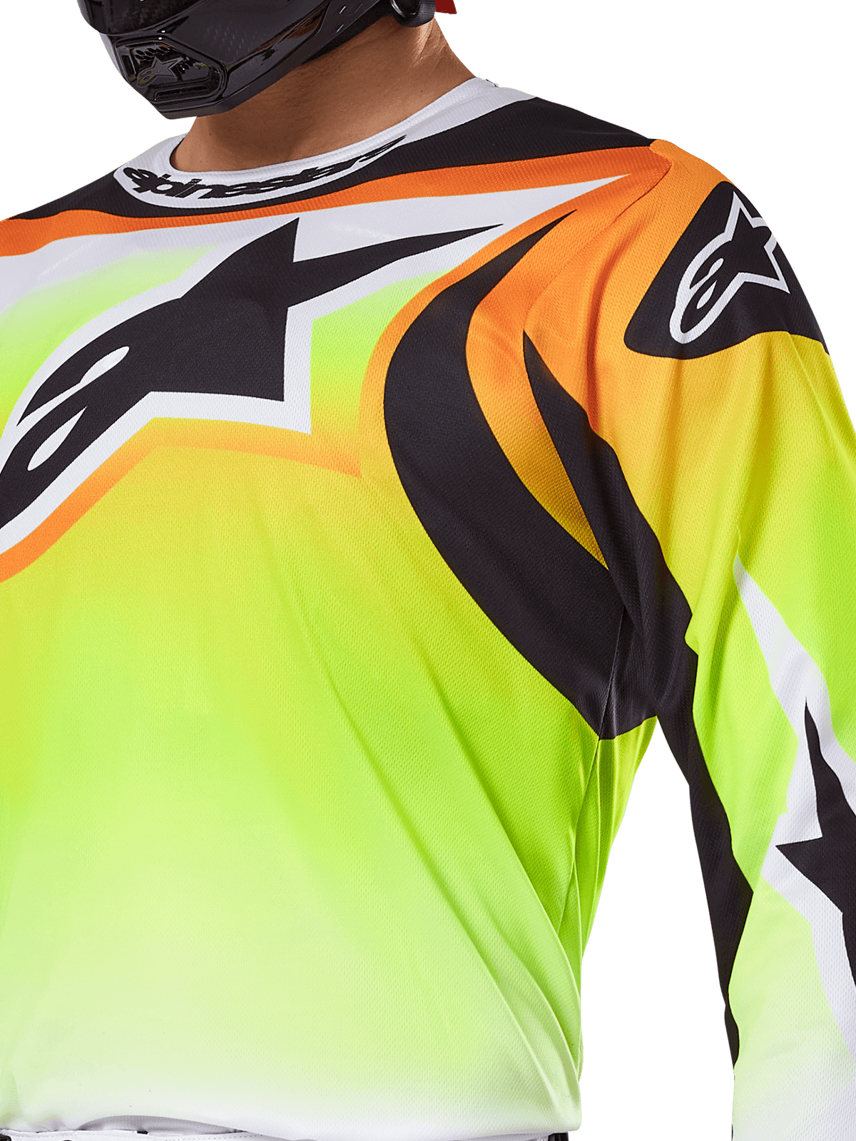 Koszulka Alpinestars Fluid Wurx 2025, koszulka motocrossowa, neonowożółta z czarną i pomarańczową grafiką, duże czarne logo Alpinestars na klatce piersiowej i ramieniu, noszona przez motocyklistę w czarnym kasku