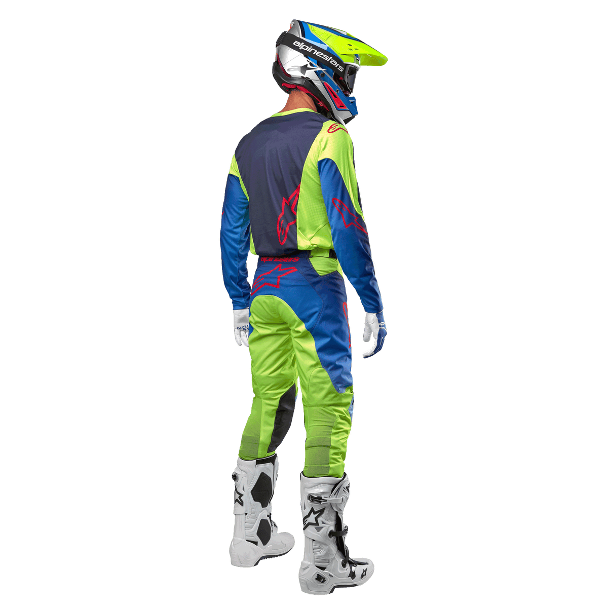Zawodnik motocrossowy widoczny od tyłu w koszulce Alpinestars 2024 Racer Hoen w kolorze żółtym neonowym i granatowym, dopasowane spodnie motocrossowe i białe buty, pokazujący tylny design z czerwonymi logo, profesjonalny strój do wyścigów terenowych
