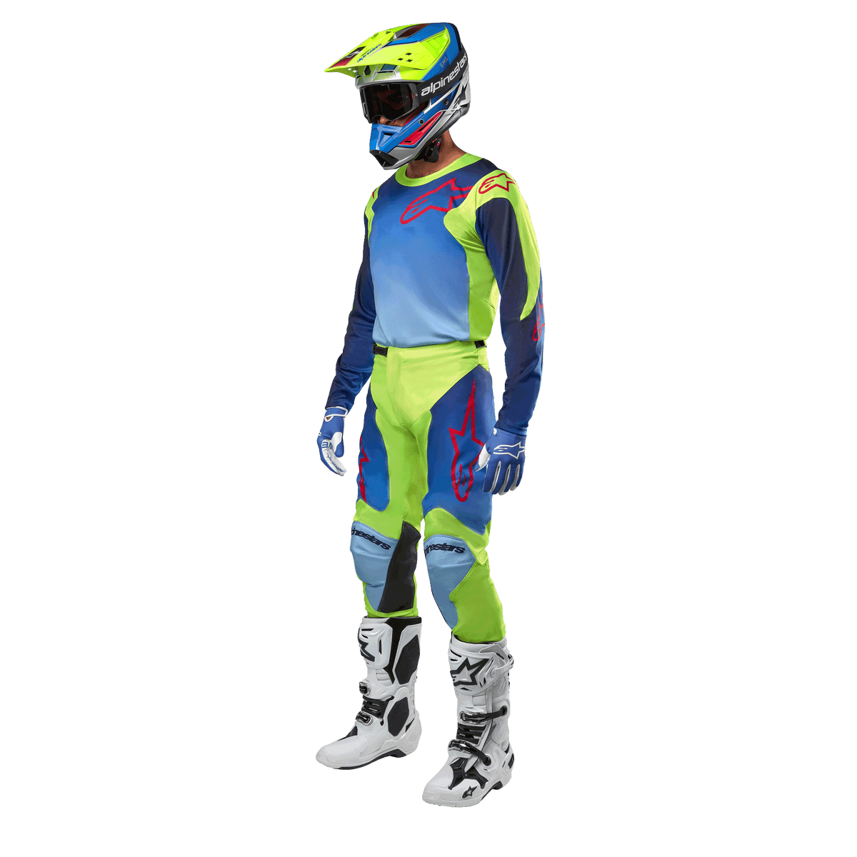 Alpinestars 2024 Racer Hoen Jersey, koszulka motocrossowa, żółta fluorescencyjna i granatowa, noszona przez motocyklistę z dopasowanymi spodniami, kaskiem i białymi butami, profesjonalny sprzęt wyścigowy do jazdy terenowej