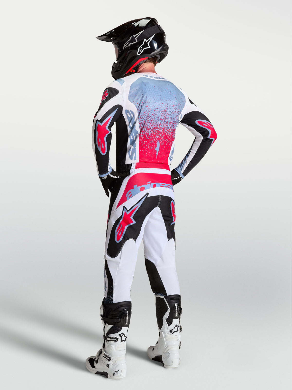 Alpinestars Fluid Drag Gear Set, męski zestaw odzieży motocrossowej, biały, czerwony i czarny, grafika z efektem sprayu, widok od tyłu.