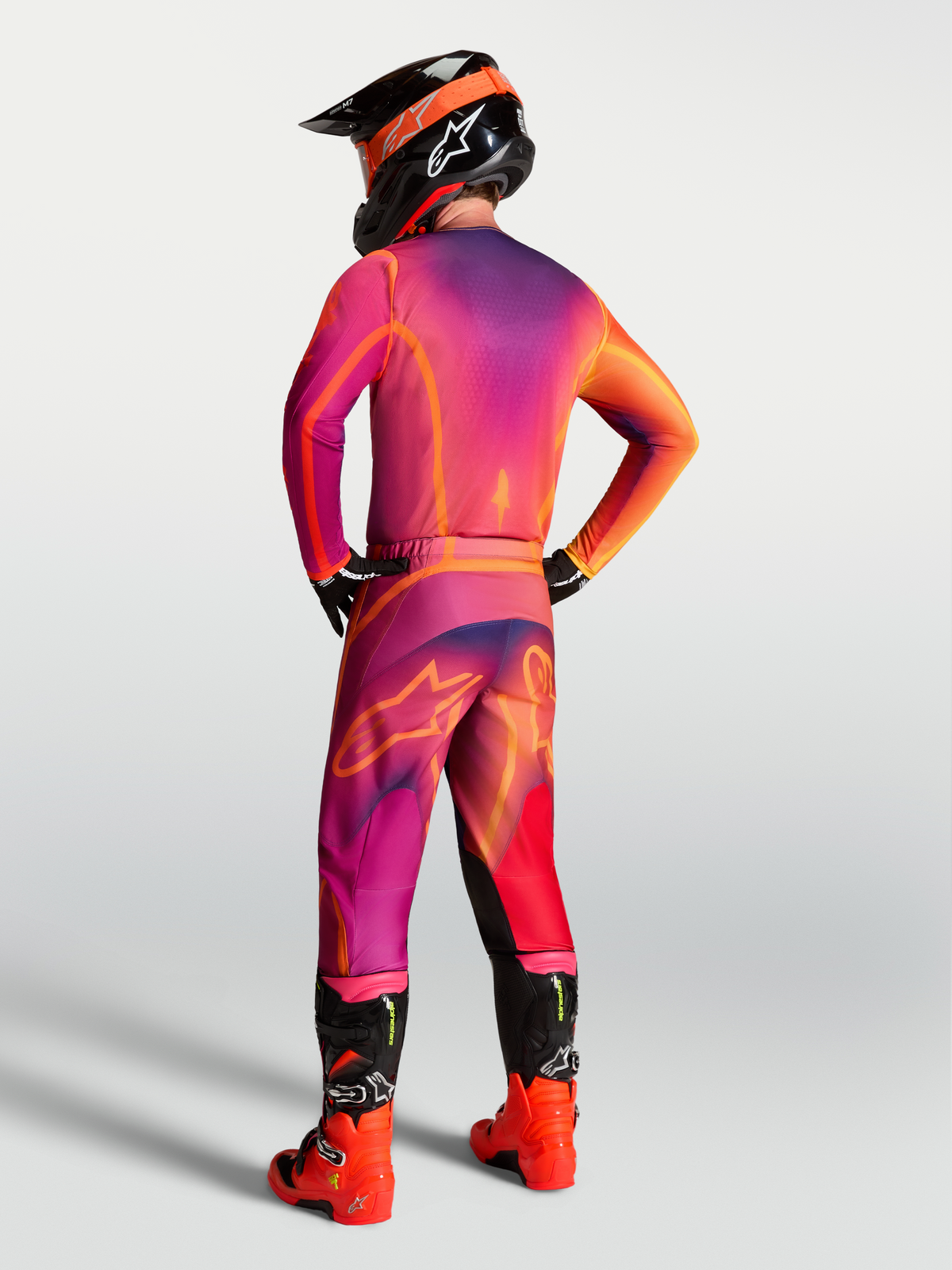 Spodnie Alpinestars Fluid Kepler, męskie spodnie MX, fioletowe i pomarańczowe, tył pokazujący ergonomiczny sportowy krój.