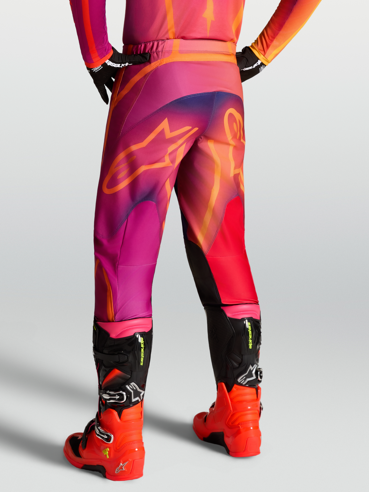 Alpinestars Spodnie Fluid Kepler, męskie spodnie motocrossowe, fioletowe i pomarańczowe, konstrukcja z poliestru 600D, panele ze stretchu, ergonomiczny sportowy design do jazdy off-road.