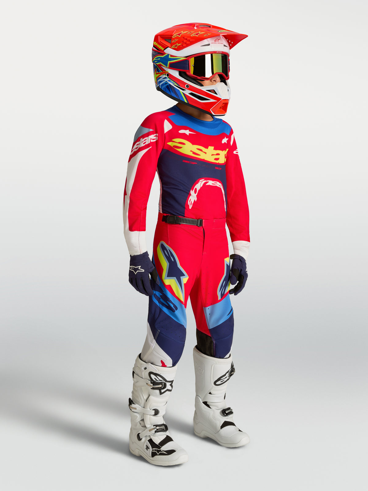 Alpinestars młodzieżowy zestaw Supertech Dyna 2027, czerwony i granatowy, strój MX na zawodniku w białych butach.
