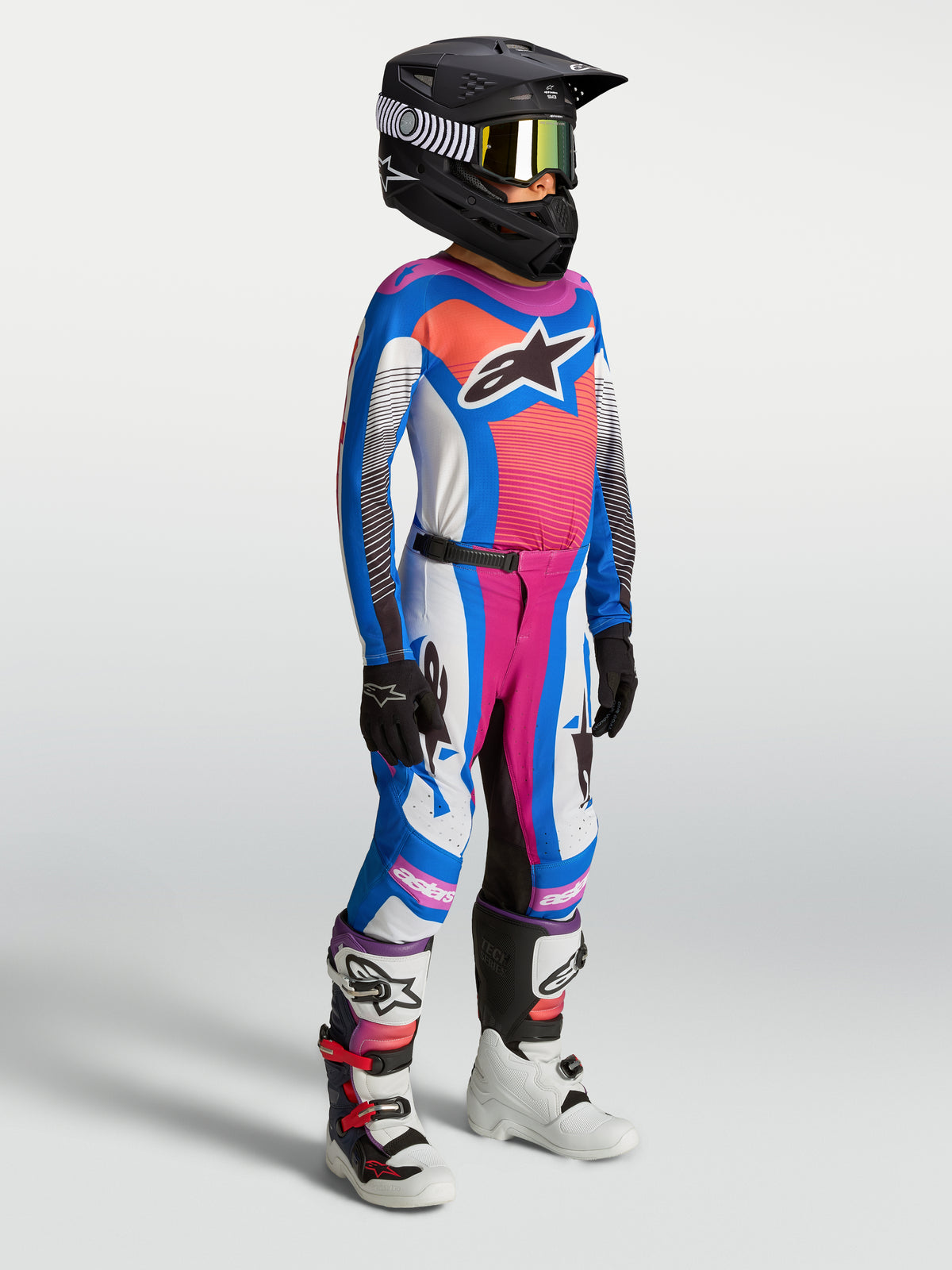 Alpinestars młodzieżowy zestaw Supertech Maven 2027, niebiesko-koralowa odzież MX z elastycznej siatki, widok na modelu.