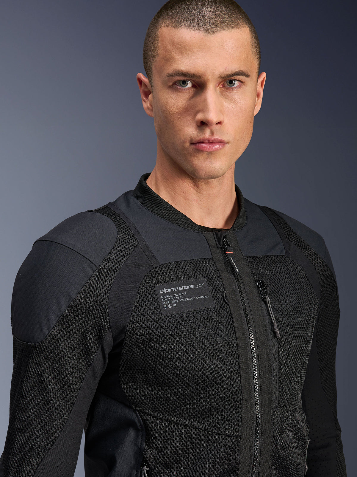 Kurtka Alpinestars Troop-Air Pro, czarna, techniczna motocyklowa kurtka z pancerzem typu air, zbliżenie pokazujące strukturę siatki 2D oraz naszywkę z logo na piersi