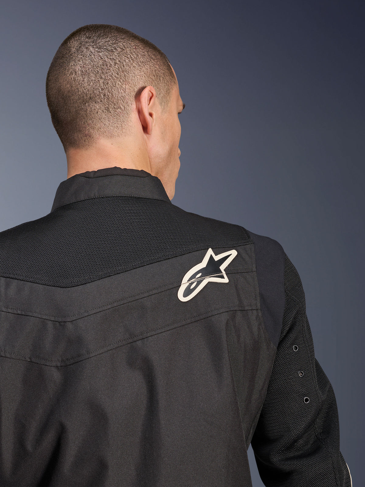 Alpinestars T-Dyno Air Jacket, Black textile motorcycle jacket, close-up back view highlighting the breathable 3D mesh yoke and sleeves, featuring a white and black star logo on the right shoulder.