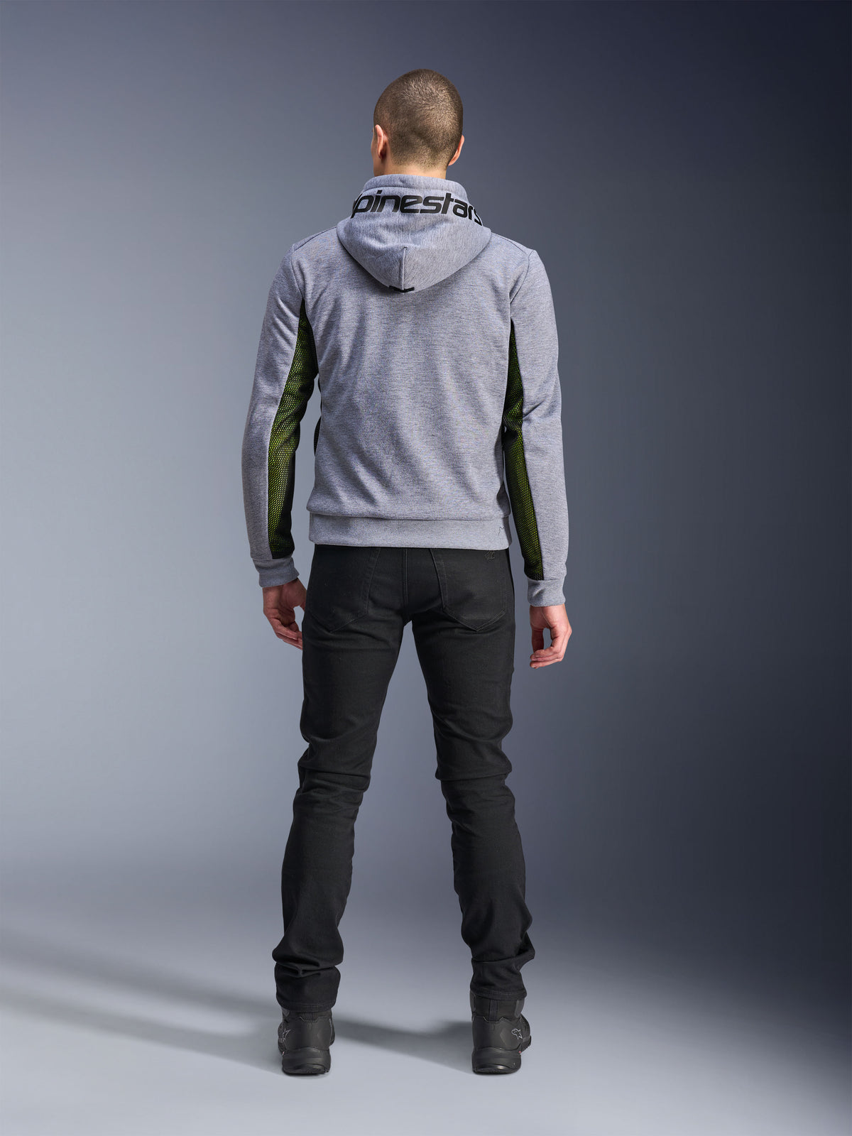 Alpinestars Chrome Air Sport Hoodie, Gray Heather Black, widok od tyłu motocyklowej bluzy z kapturem z zielonymi panelami z siatki o wysokim przepływie powietrza na bokach i rękawach, konstrukcja z technicznego polaru z logo Alpinestars na kapturze, zestawiona z czarnymi spodniami