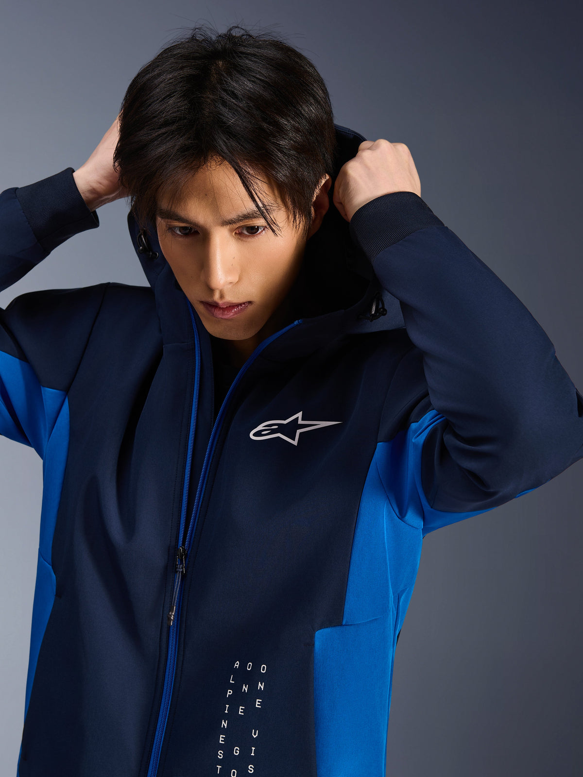 Alpinestars Radium Tech Hoodie, miejska kurtka motocyklowa, w kolorach Night Navy i Royal Blue, model poprawiający kaptur, białe logo Astars na piersi, techniczna konstrukcja 3L tech shell o sportowym kroju