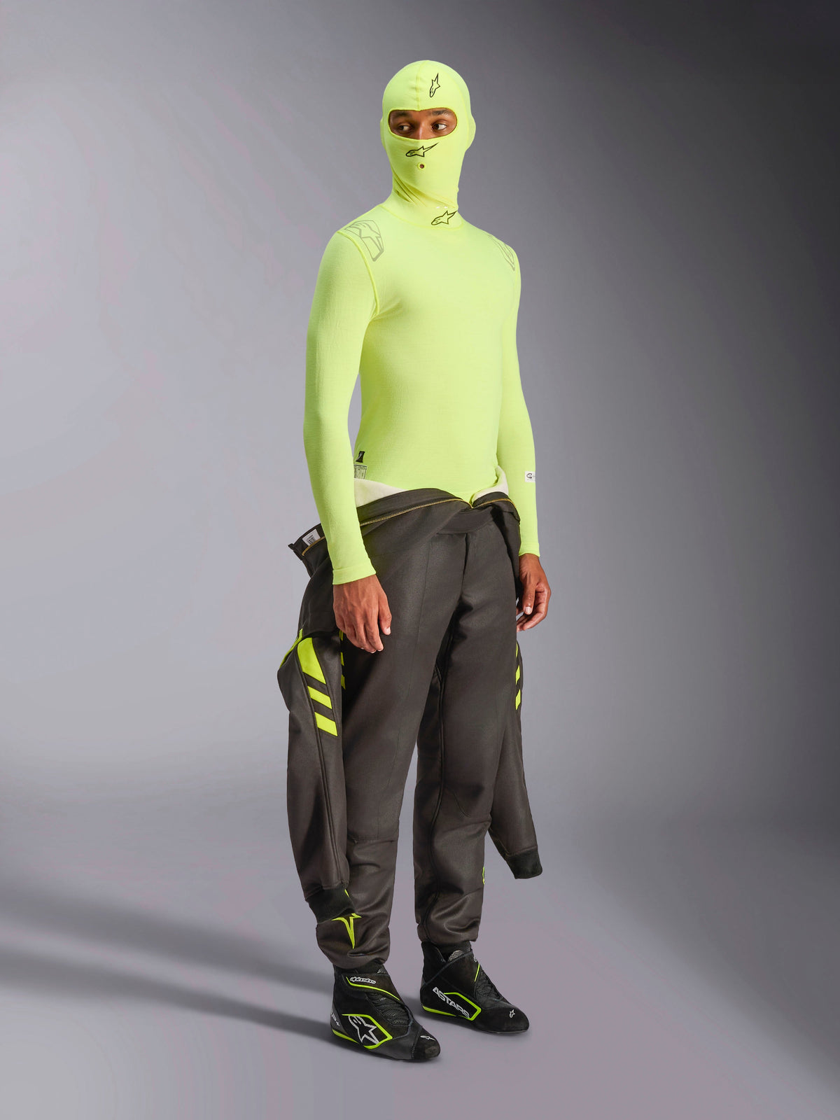Alpinestars ZX Evo V3 Long Sleeve Top, Yellow Fluo, bielizna termoaktywna do sportów motorowych noszona z pasującą kominiarką i ciemnym kombinezonem wyścigowym przewiązanym w pasie, neonowożółta bielizna ognioodporna o wysokiej widoczności