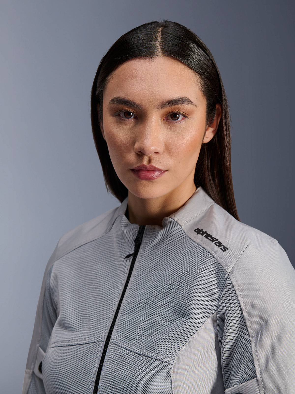 Kurtka Alpinestars Stella C-1 Air, damska srebrna kurtka motocyklowa, zbliżenie portretowe prezentujące panele wentylacyjne z siatki technicznej i czarne logo na ramieniu, nowoczesna miejska odzież motocyklowa