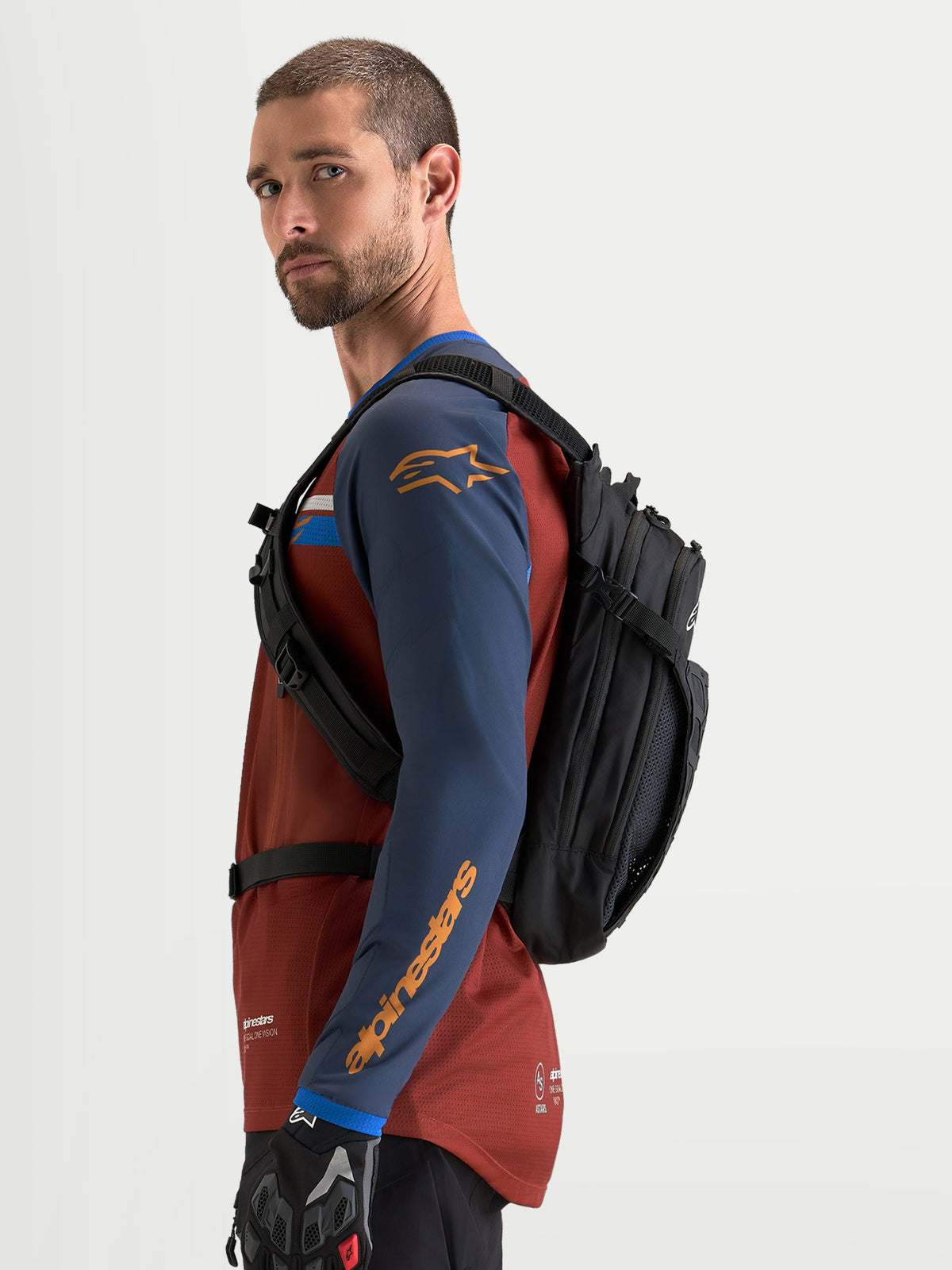 Alpinestars Plecak AT-9, plecak motocyklowy i motocrossowy, czarny, widok z boku na modela ubranego w odzież jeździecką
