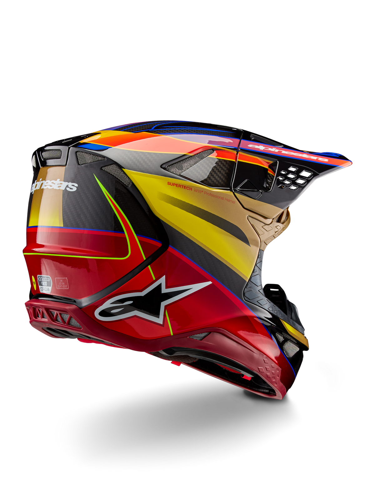 Alpinestars Supertech M10 Era, kask motocrossowy, złoto-żółty i czerwony Rio z połyskiem, widok z tyłu pod kątem trzech czwartych ukazujący skorupę z włókna węglowego, czerwone i żółte grafiki, niebieskie akcenty, aerodynamiczny profil, liczne otwory wentylacyjne i logo Astar