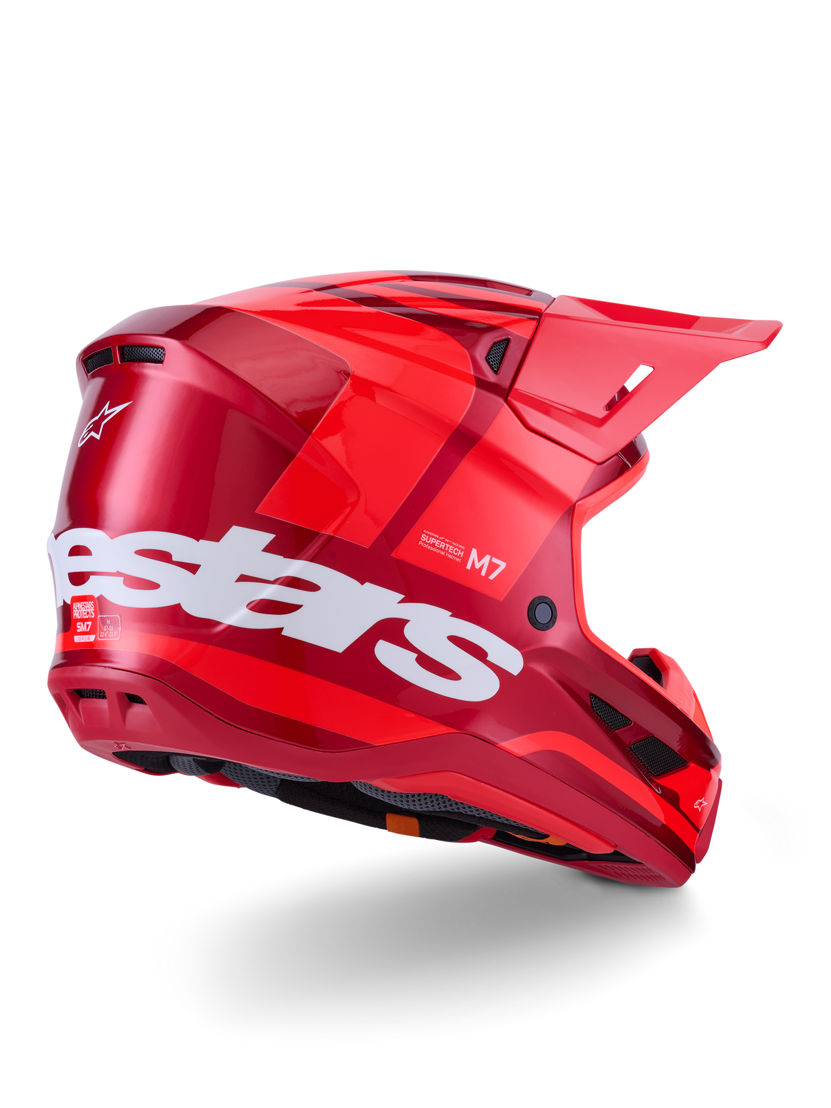 Kask Alpinestars S-M7 Core, kask motocrossowy, czerwony błyszczący z dużym białym logo Alpinestars z boku, posiadający aerodynamiczną skorupę, zintegrowane otwory wentylacyjne i daszek ochronny, widok 3/4 z tyłu