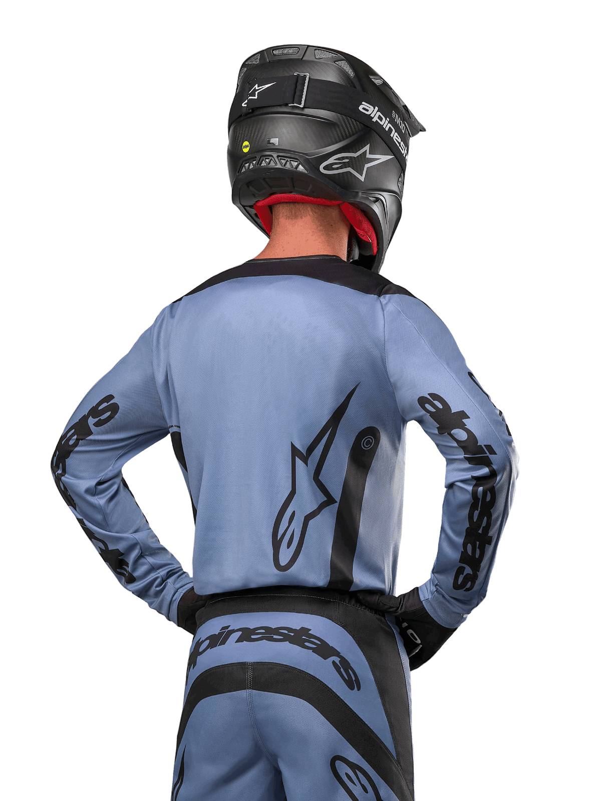 Koszulka Alpinestars Fluid Lurv 2024, koszulka motocrossowa, niebiesko-czarna, widok od tyłu przedstawiający duże logo gwiazdy i branding na rękawach, noszona z czarnym kaskiem i pasującymi spodniami off-road, profesjonalna odzież wyścigowa