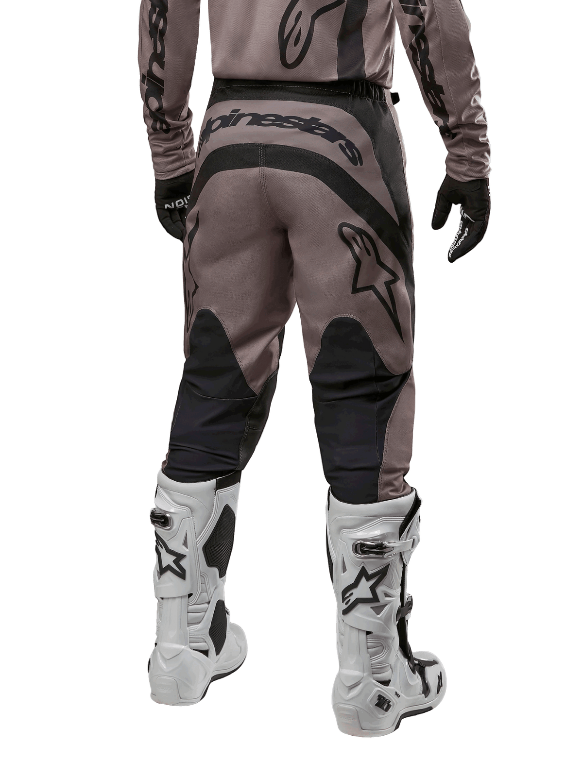 Alpinestars 2024 Fluid Lurv Pants, spodnie motocrossowe, kolor Mud Black, widok z tyłu ukazujący duże czarne logo Alpinestars na siedzeniu oraz czarne panele na łydkach, zestawione z biało-czarnymi butami motocrossowymi i pasującą koszulką