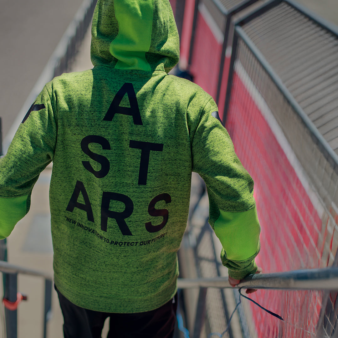 Alpinestars Perpetuate Hoodie, widok z tyłu, limonkowy melanżowy polar, duża czarna grafika z napisem ASTARS na plecach, casualowa odzież sportowa z panelami z tkaniny i kapturem ze sznurkiem