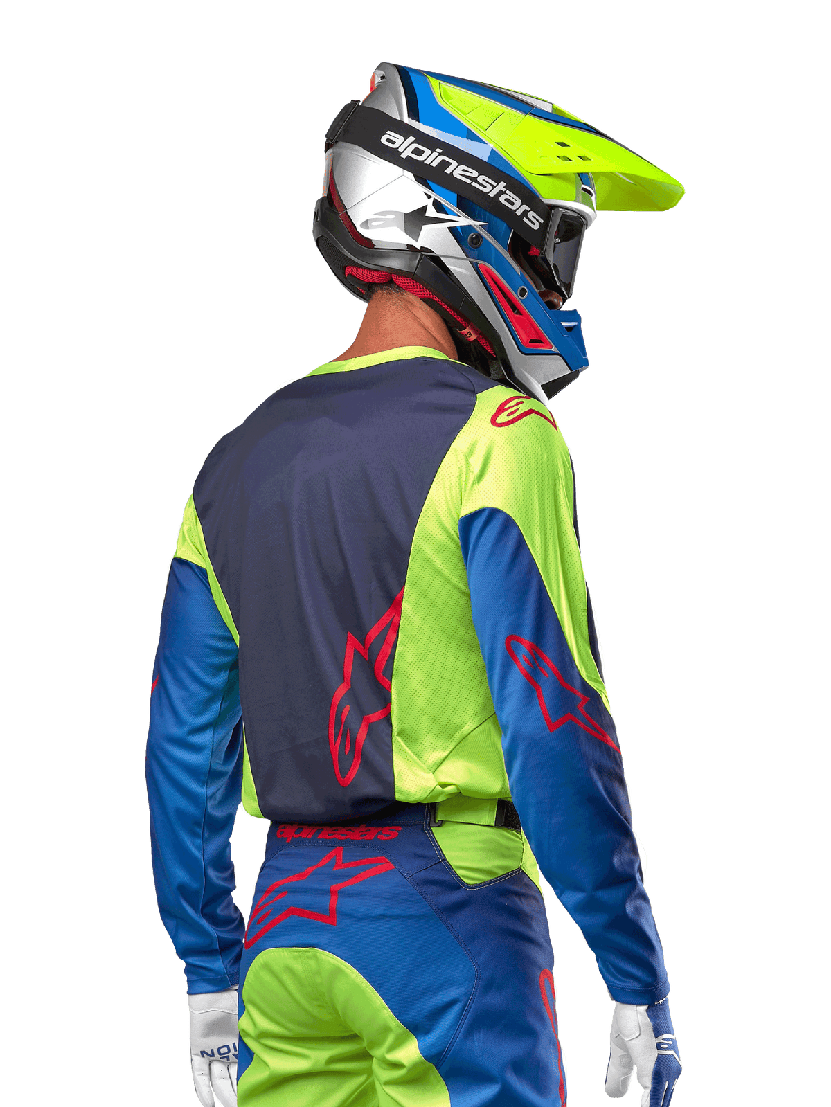 Motocyklista motocrossowy w koszulce Alpinestars 2024 Racer Hoen, kolor żółty fluo i granatowy (Blue Night Navy), z czerwonym logo gwiazdy na plecach, pasujące spodnie i kask wyścigowy, widok z tyłu prezentujący ergonomiczny design do jazdy terenowej.