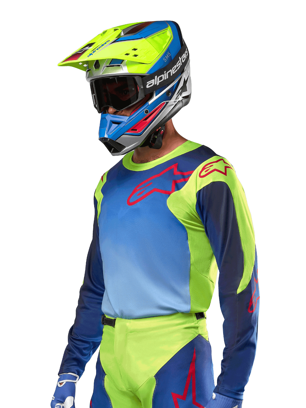 Koszulka Alpinestars Racer Hoen 2024, koszulka motocrossowa, kolory żółty fluo i granatowy z czerwonymi logotypami, noszona z pasującym żółto-niebiesko-czerwonym kaskiem i niebieskimi rękawicami, wyrazisty strój do jazdy terenowej