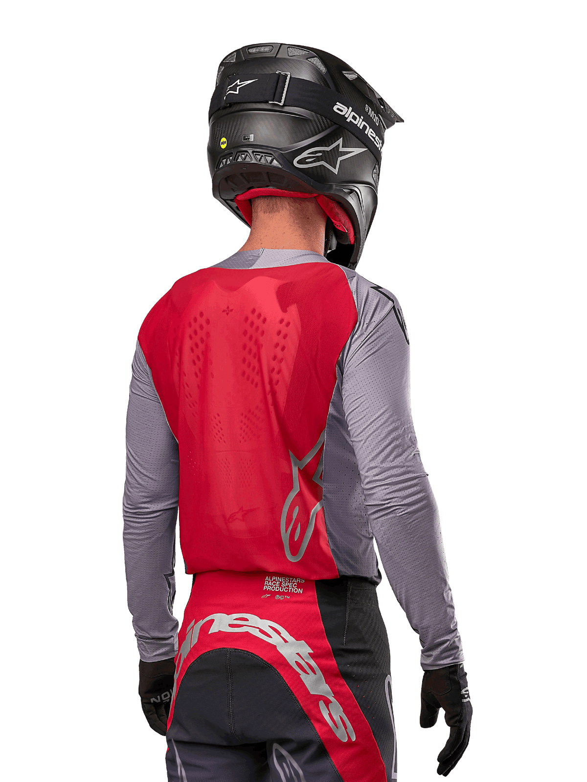 Kierowca motocrossowy widziany od tyłu w koszulce Alpinestars 2024 Supertech Dade w kolorze Iron Red Berry i szarym, z oddychającym panelem z siatki na plecach i srebrnymi akcentami logo, w zestawie z czarnym kaskiem i dopasowanymi spodniami wyścigowymi, zapewniający profesjonalną wydajność off-road
