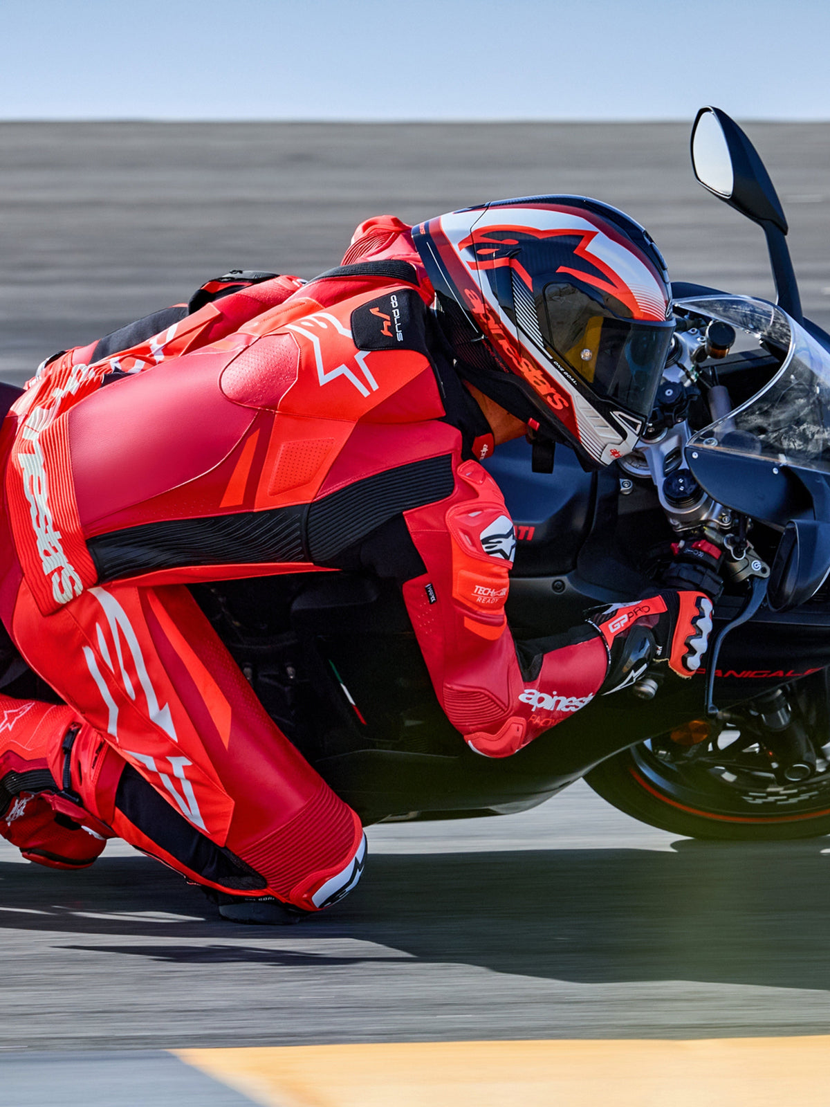 Alpinestars GP Plus V4 Sprint 1PC, skórzany kombinezon wyścigowy, czerwony i biały, Tech-Air® Ready, motocyklista na torze.