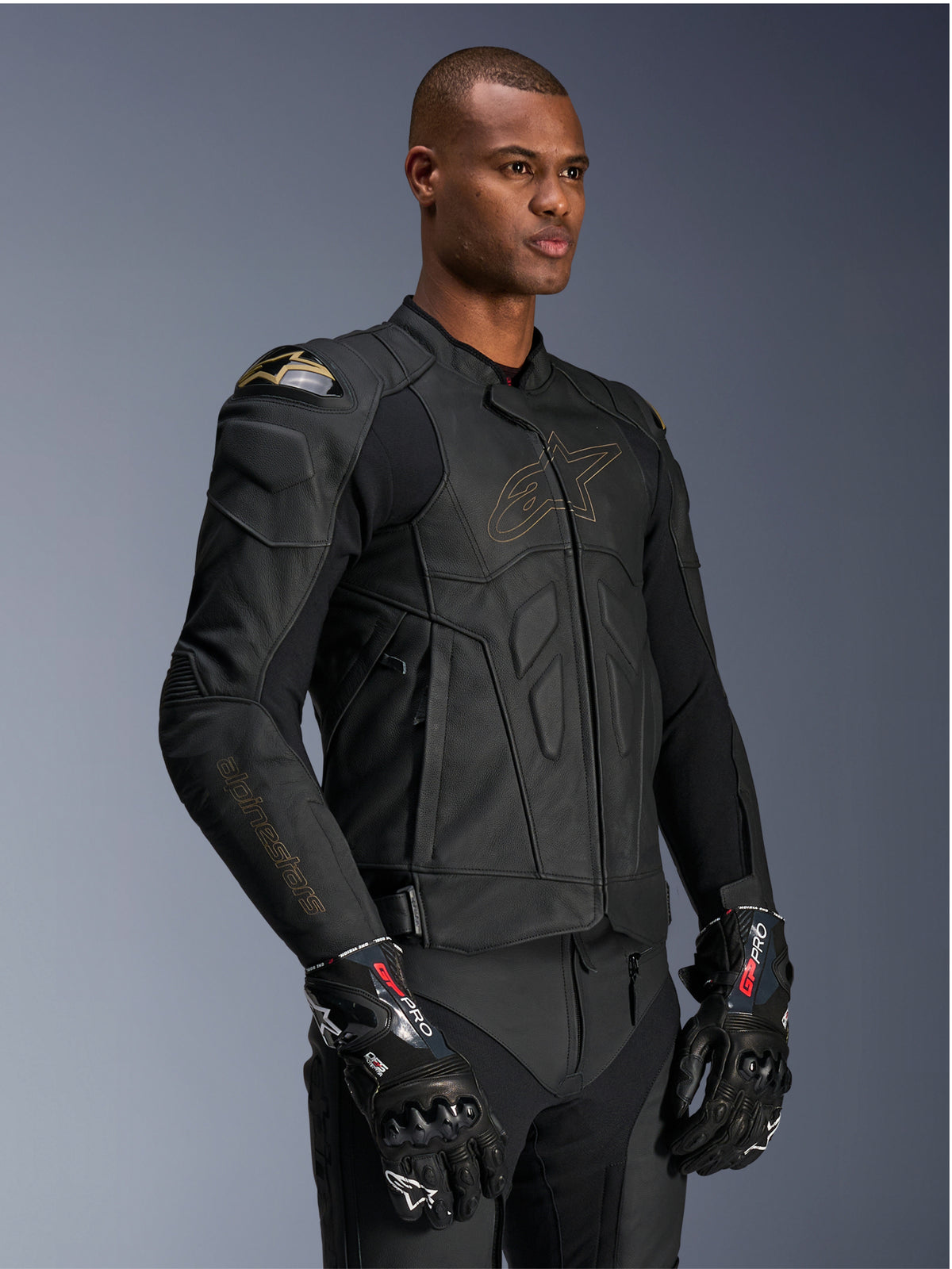 Alpinestars Kurtka Dusk Skórzana, męska czarna kurtka motocyklowa, ochrona ramion DFS, złote logo, model w rękawicach GP Pro.