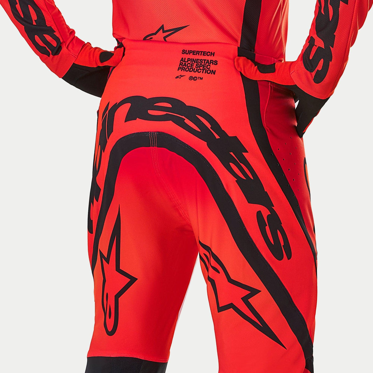 Alpinestars Supertech Ember LE Pants, Motocross Pants, Red Fluo and Bright Red with Black graphics, rear view highlighting bold branding and 'Race Spec Production' text on the lower back, performance-engineered design for off-road racing