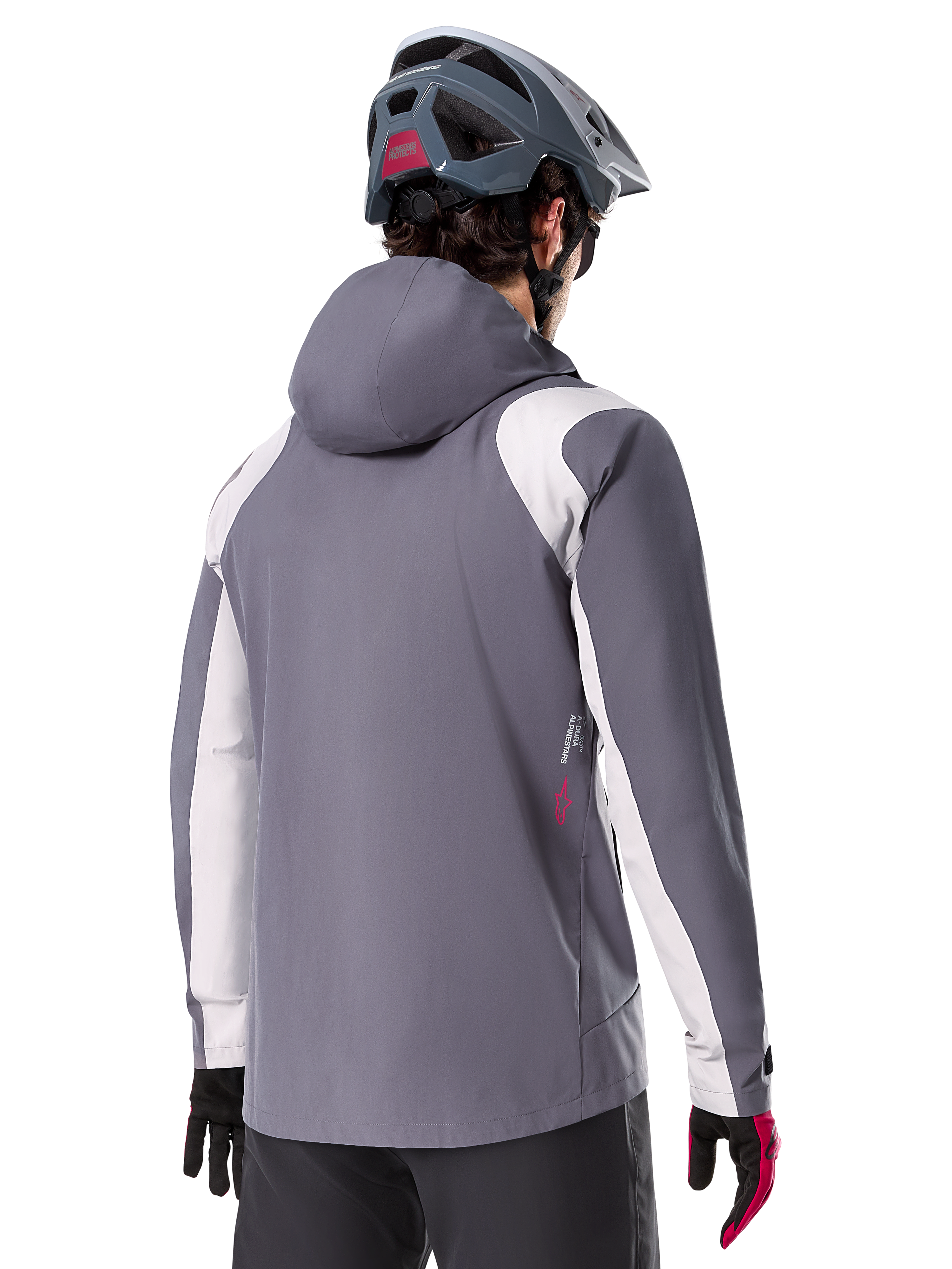 Alpinestars A-Dura Rain Jacket, kurtka przeciwdeszczowa MTB, ciemnoszara (Dark Titanium), widok z tyłu z jasnoszarymi panelami na ramionach i rękawach, czerwone logo z boku, noszona z szarym kaskiem MTB i czarno-czerwonymi rękawicami, techniczna odzież trailowa