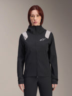 Alpinestars Stella A-Dura Rain Jacket, damska rowerowa kurtka przeciwdeszczowa, czarna z jasnoszarymi panelami na ramionach, techniczna kurtka z kapturem i białym logo na piersi, regulowane mankiety na rzepy, profesjonalna odzież do MTB i jazdy w deszczu